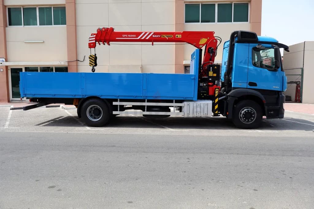White boom truck crane with the crane folded behind the cab