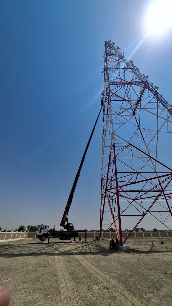 Manlift basket beside satellite dishes on a telecom tower