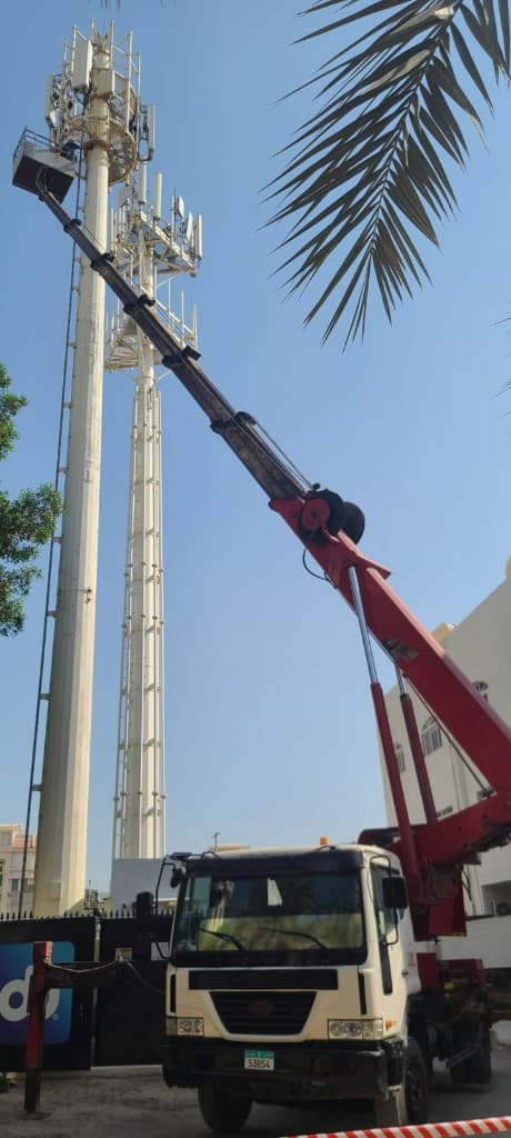 Truck-mounted manlift working on a telecom tower in Abu Dhabi